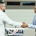 Dua orang berjabat tangan di atas meja setelah berhasil mencapai closing penjualan